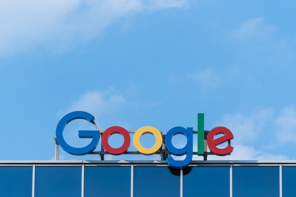 colorful Google business sign on building against blue sky with clouds