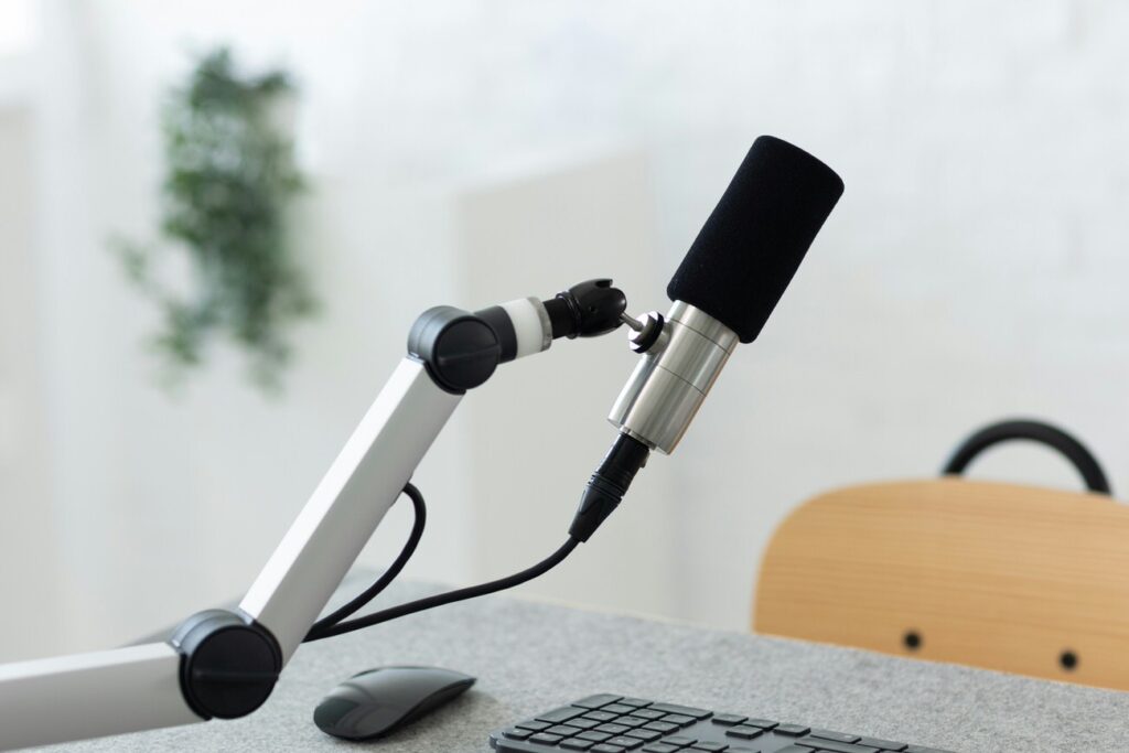 podcasting mic on boom arm at empty desk with keyboard and mouse